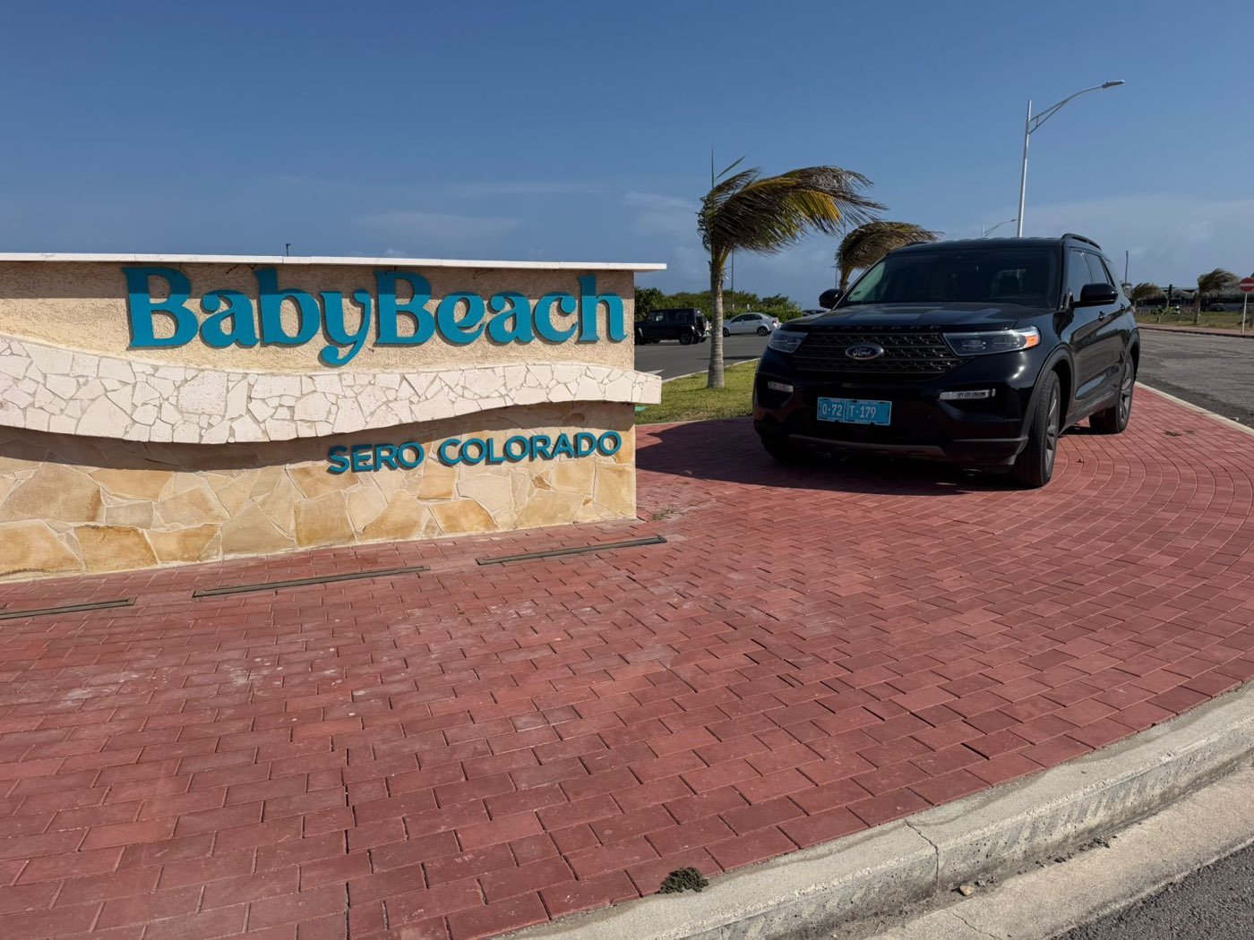 A Dushi Transfers SUV at the Baby Beach sign in Seroe Colorado