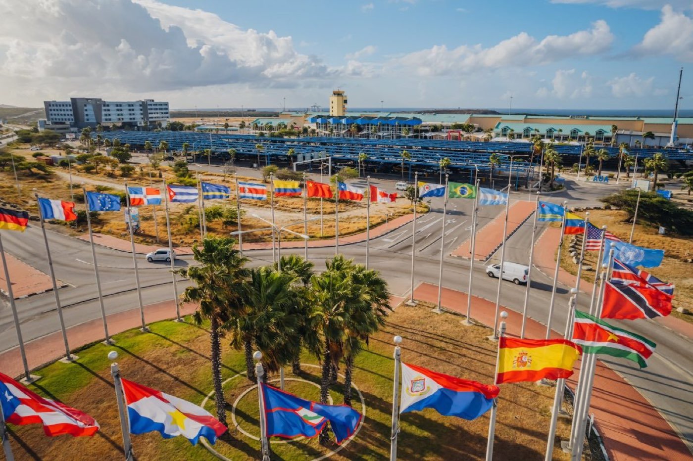 Flags and palm trees at the approach to Aruba's Queen Beatrix airport
