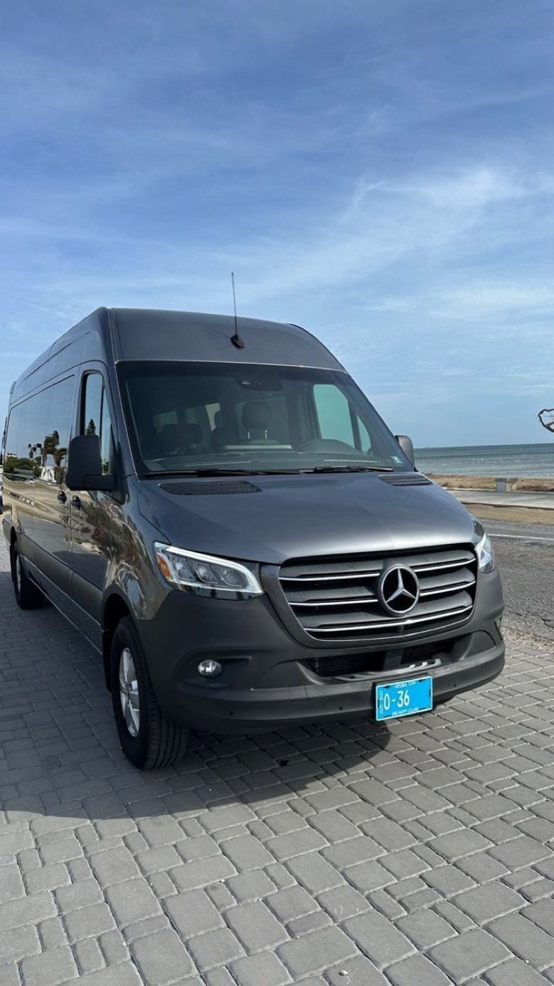 A Dushi Transfers Mercedes-Benz Sprinter parked on a paved street